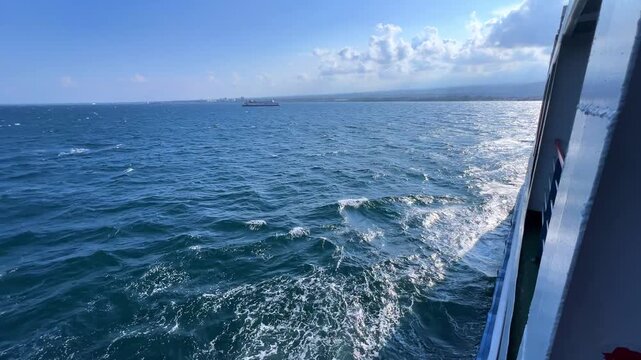 Bali, Indonesia - August 27, 2025: Car and passenger ferries cross the Bali Strait from Gilimanuk Harbor to Ketapang Harbor. View of the strait from the ferry deck. 4К