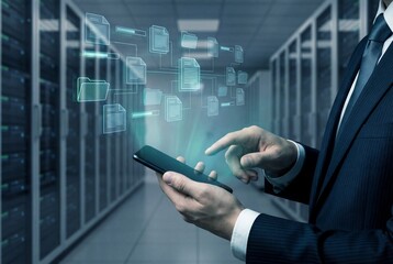Businessman managing digital files on smartphone with hologram interface in server room