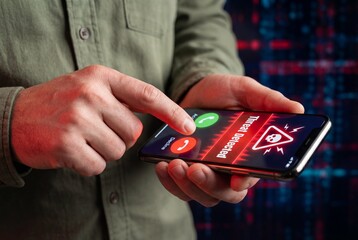 Man holding mobile phone with red threat detected warning on screen indicating cyber security danger