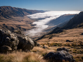 Expansive mountain valley landscape showcasing a dramatic cloud inversion beneath a brilliant blue sky
