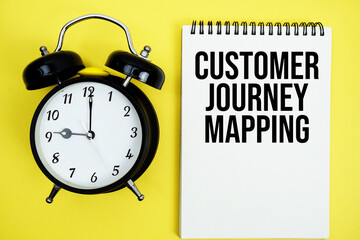 Customer Journey Mapping text with alarm clock flat lay on yellow background