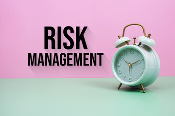 Black alarm clock on a pastel green and pink background with the text "Risk Management"