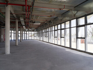 Unfinished space with exposed pipes and windows