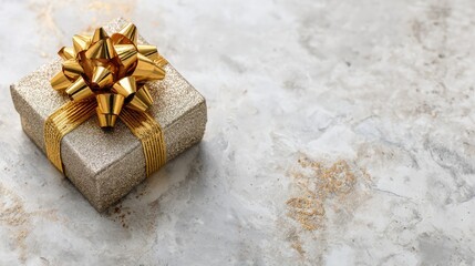 Elegant gold gift box with shiny bow on marble background perfect for holidays, celebrations, or special occasions in upscale decor