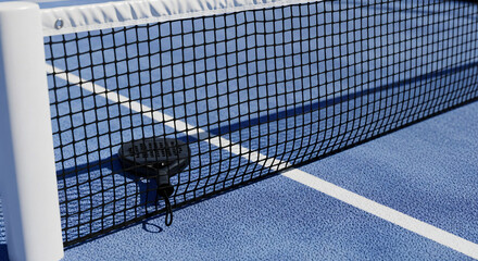 Close up view of padel tennis racket resting on blue court near net
