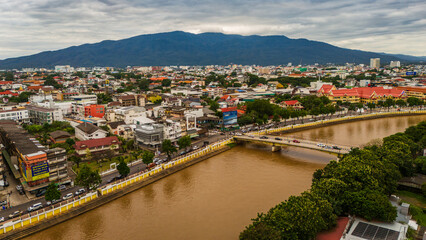 Cinematic aerial drone view of Chiang Mai city at golden hour sunset, featuring the winding Ping...