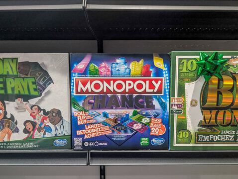 Canada, Quebec, 20 December 2025 : Colorful Monopoly Chance board game box surrounded by other money games