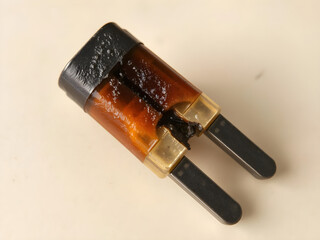 A burnt out battery is sitting on a white surface