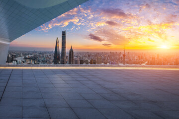 Empty square floor and modern city skyline with tall skyscrapers at sunset in Shanghai