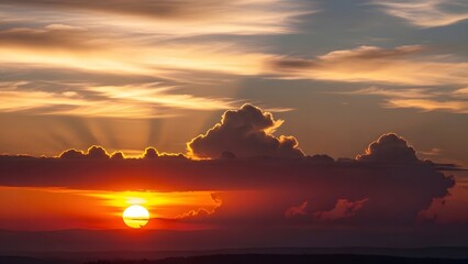 Sunset glow behind dramatic clouds with radiant beams streaming through sky in vivid warm and cool tones