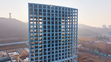 unfinished high-rise building, construction stalled due to financial deficit, reflecting economic...