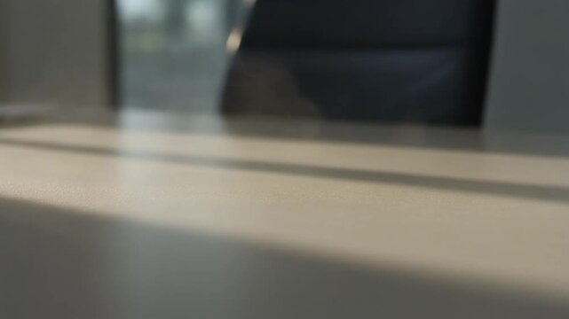 Blurred office desk with sunlight and shadows.
