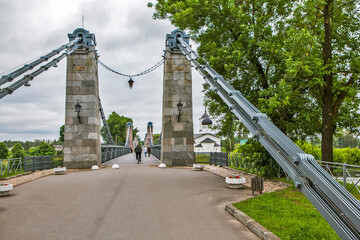 The Chain Bridge over the Velikaya River and the Church of St. Nicholas the Wonderworker (Nikolskaya). Ostrov, Pskov Oblast, Russia