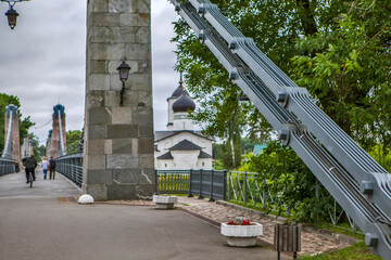 The Chain Bridge over the Velikaya River and the Church of St. Nicholas the Wonderworker (Nikolskaya). Ostrov, Pskov Oblast, Russia