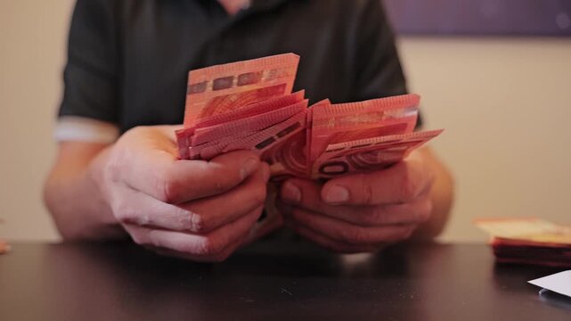 Tight focus on cash counting hands showing economic inequality and restraint