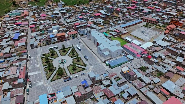 Drone performs a corkscrew descent directly into the central plaza of Cabanaconde, Peru. Footage highlights the rural village layout, streets, and central gathering area in immersive cinematic style.