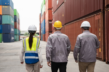 Back engineer and worker team working in logistic terminal of container cargo, Diverse construction team in safety gear outdoors