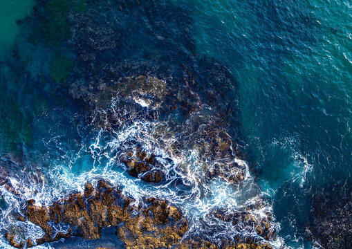 Dramatic coastline. Tropical sea aerial. Clear turquoise water coastline. Ocean surf. Drone shot of beauty rocky coastline. Rocky coast with sea foam. Summer beach with crashing waves.