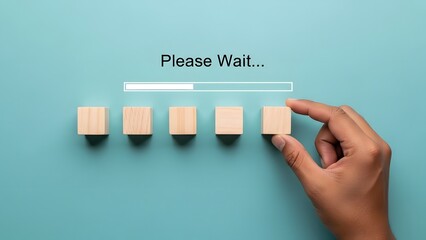 A hand placing a wooden block into a sequence, symbolizing progress and development, with a 'Please Wait...' loading bar above on a blue background.