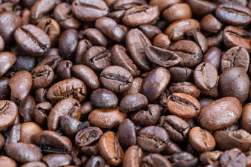 Fototapeta premium Striking contrast lighting reveals texture and shine of coffee beans, High contrast illumination vividly enhances appearance and surface quality of roasted coffee beans