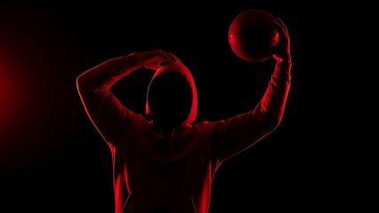 Silhouette of a basketball player preparing to shoot in dramatic red lighting
