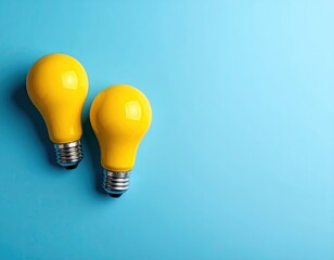 Two yellow lightbulbs on a bright blue backdrop