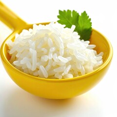 Cooked white grains in a yellow spoon with green sprig