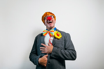 Businessman clown laughing with red nose and colorful bow tie
