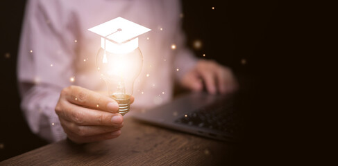 A man with his laptop holding glowing lightbulb with graduation cap. Online digital education, e-learning, self learn, improvement, and development, knowledge and educational tools and technology.