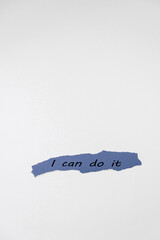 A torn piece of blue paper with the text 'I can do it' written in black. The background is plain white, creating a minimalist and motivational aesthetic.