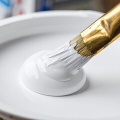 Brush dipping into white paint in a circular tray, close-up shot