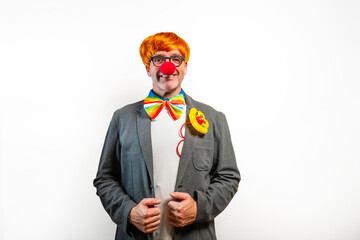 Clown wearing red nose and rainbow bowtie smiling at camera