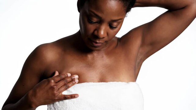 African american woman in towel checking underarm isolated on white background