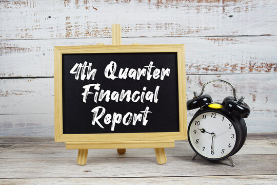 4th Quarter Financial Reporttext written on blackboard with alarm clock on wooden background