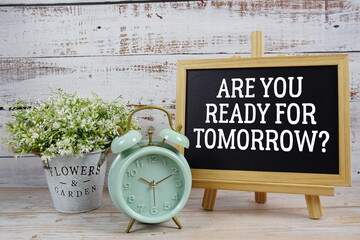 Are You Ready For Tomorrow? text written on blackboard with alarm clock on wooden background