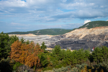Panoramic aerial view of coal mine. Open pit mine industry, big yellow mining truck for coal quarry. Open coal mining anthracite mining. Pit on coal mining by open way. 