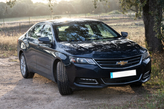 Badajoz, Spain - 10 June 23: Blue Chevrolet Impala sedan on a dirt road