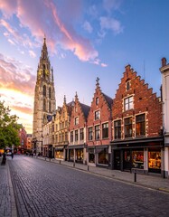 Fototapeta premium Cobblestone Street Lined with Historic Buildings at Sunset