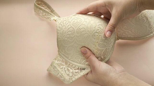 Female hands touch the soft push-up of a woman's bust. Women's Underwear