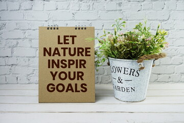 Let Nature Inspire Your Goals Motivational And Inspirational Quotes on white brick wall and wooden...