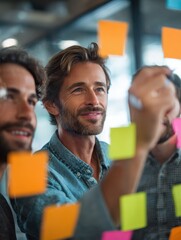 creative group of business people brainstorming putting sticky notes on glass wall in office