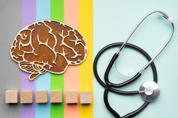 Mock up of the human brain with stethoscope on a colorful background. Six cubes in which you can write the word autism in your font.
