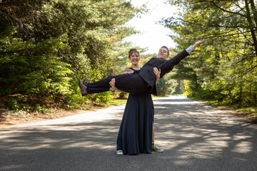 Young woman holds a young man and strikes a pose in formalwear © Cavan