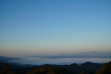 Mountain Range Under Clear Blue Sky with Soft Clouds