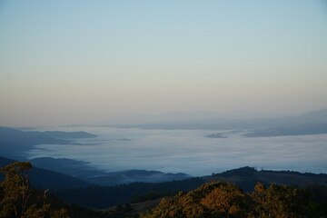 Mountain Range Under Clear Blue Sky with Soft Clouds