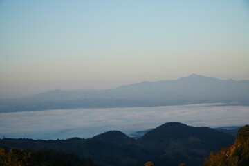 Mountain Range Under Clear Blue Sky with Soft Clouds