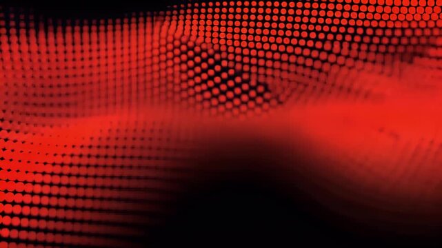 Abstract flowing wave of red dots on a black background creating a dynamic and energetic digital art pattern with a blurred foreground and sharp details in the midground.