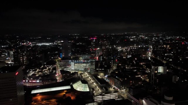 Aerial view at night shows traffic moving through illuminated Manchester intersection