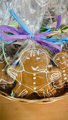 Close-up of a gingerbread man cookie in transparent gift packaging with a colorful ribbon bow.