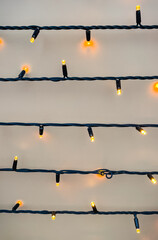 Warm Christmas fairy lights glowing on a rustic brown wooden background with copy space for text.